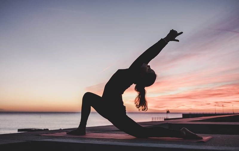 Woman meditating at sunrise
